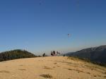 Paragliding Fluggebiet ,,Startplatz kurz vor dem Sonnenuntergang mit dem aufgehenden Mond zwischen den fliegenden Schirmen im Hintergrund.