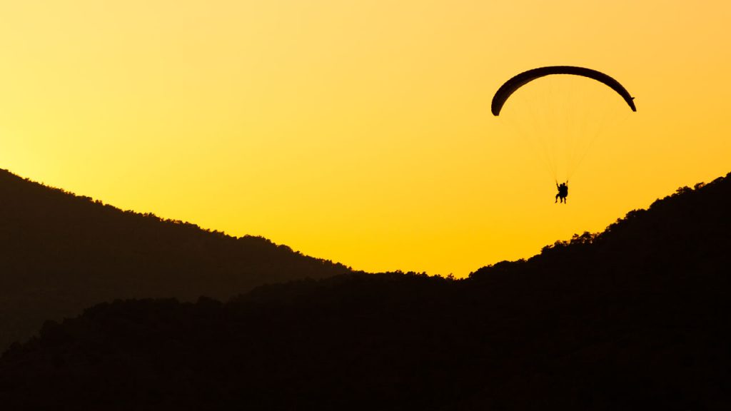 Ein Tandem-Gleitschirm fliegen bei Sonnenuntergang