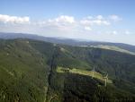 Paragliding Fluggebiet Europa » Deutschland » Baden-Württemberg,Schauinsland,Blick zum Fluggebiet Schauinsland.Ich befinde mich knapp 1000m über der Landewiese.Links im Bild der Schauinslandgipfel (1284m NN)mit dem Aussichtsturm,etwa in Bildmitte die Bergstation der Schauinslandbahn (1220m NN),rechts unten davon unser Startplatz (1180m NN),die grosse Wiesenhangfläche bei den Windrädern ist die Hölzschlägermatte(ca.950m NN).Hier ist die letzte Aussenlandemöglichkeit auf dem Weg zur Landewiese bei der Talstation,wer in diesem Bereich weniger als 1050m Höhe hat sollte eine sichere Landung auf der Holzschlägermatte vorziehen.