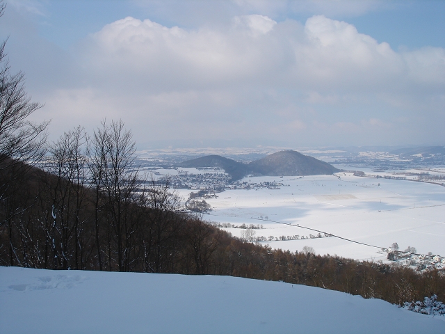 Blick West.Man erkennt das Eschweger Wahrzeichen "Die Leuchtberge".Am kleinen Leuchtberg,der links,steht ein netter Bart,der den Überflug der Stadt ermöglicht.Diese befindet sich direkt hinter diesen zwei `Bergen`.Rechts neben dem großen Leuchtberg windet sich die Werra und direkt daneben,wg.Schnee leider schlecht zu erkennen,Campingplatz mit riesigem Badesee,Sand- und Rasenstrand,Surfgelegenheit etc.