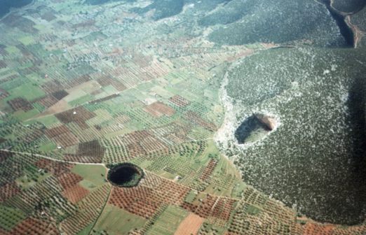 Zwei der Löcher, in das runde in der Ebene kann man über einen kleinen Zugang zwischen den Bäumen am Rand hineinsteigen.
Foto: Womblinger  1999/2000