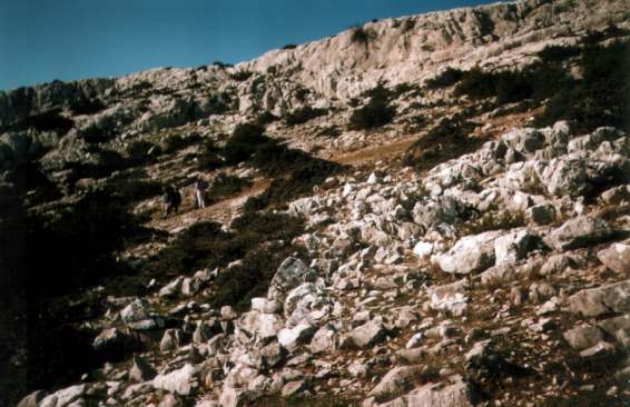 Der Südstartplatz, viele Steine, nur eine kleine, freigeräumte Fläche ausreichend für einen Schirm. Die Straße zum Gipfel verläuft oben über  der Felskante
Foto: Womblinger