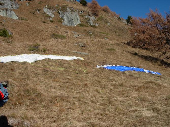 Zwei auf dem Startplatz Edelweiß ausgelegte Schirme. Unterhalb der Felswände und zwischen Baum und Windfähnchen wird gestartet.